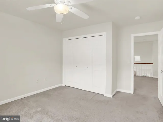an empty room with a chandelier fan