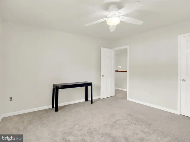 an empty room with a ceiling fan and a window