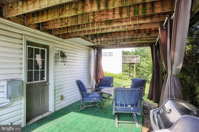a view of a porch with furniture and a yard