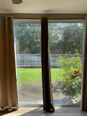 a view of a room with a large window and front view of a garden