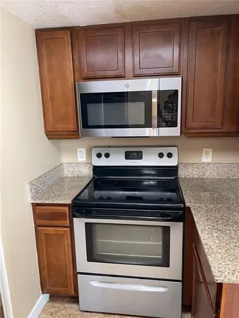 a kitchen with wooden cabinets and a stove top oven