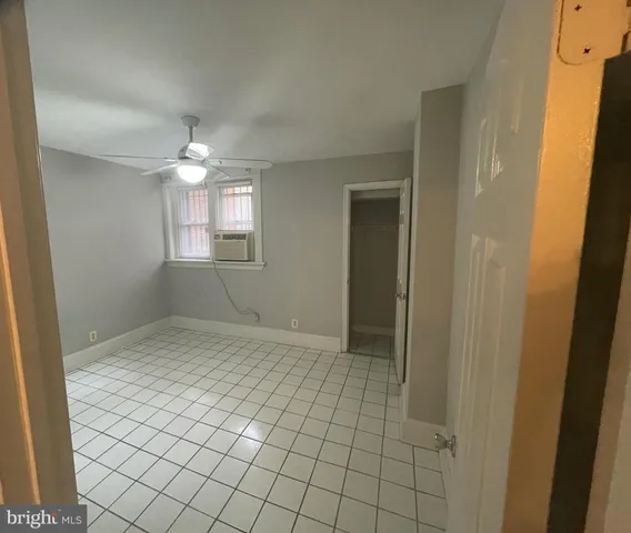 an empty room with chandelier fan