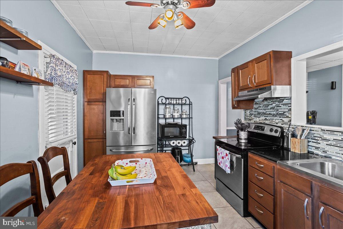 128 East Ross Street Lancaster, PA 17602 - Photo 17 of 36 a kitchen with stainless steel appliances granite countertop a stove a refrigerator a microwave oven with a dining table and chairs