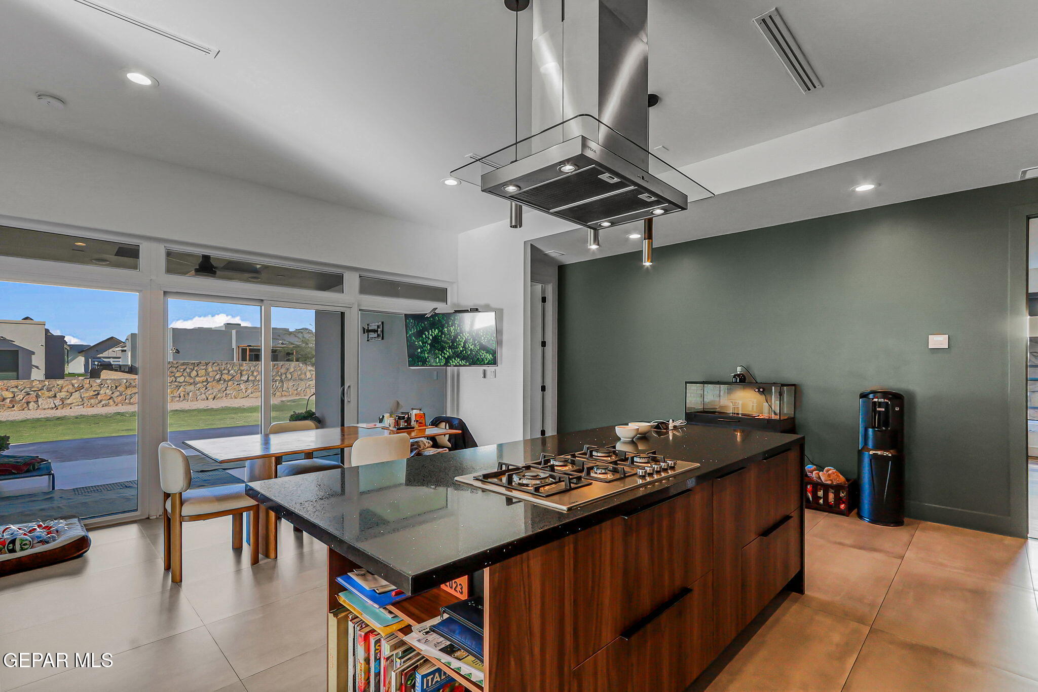 329 Rio Del Rancho Court El Paso, TX 79932 - Photo 16 of 52 a kitchen with stainless steel appliances granite countertop a stove a refrigerator a dining table and chairs with wooden floor