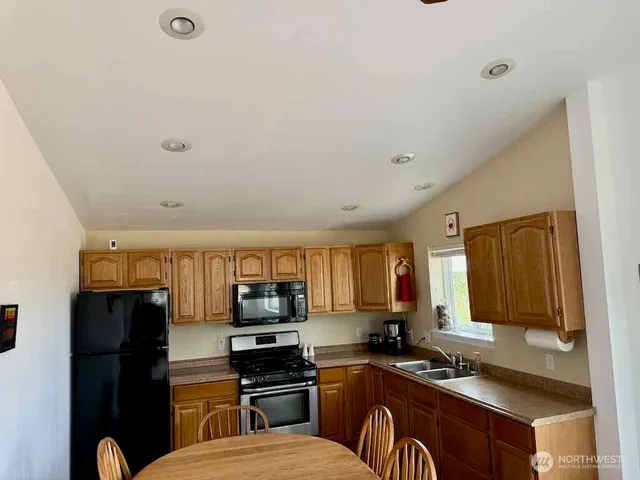 a kitchen with stainless steel appliances a refrigerator sink and stove