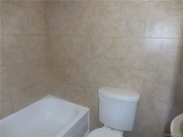 a white toilet sitting next to a shower