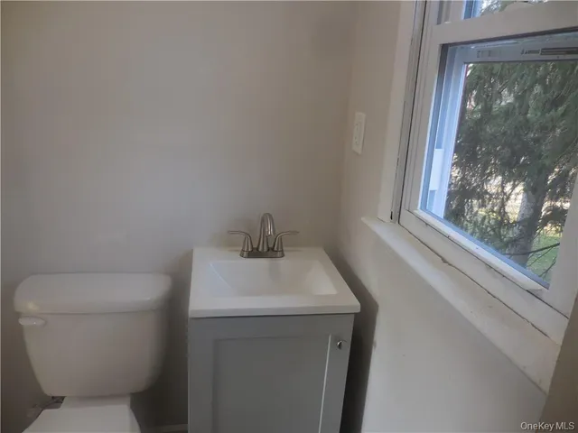 a bathroom with a toilet sink and window