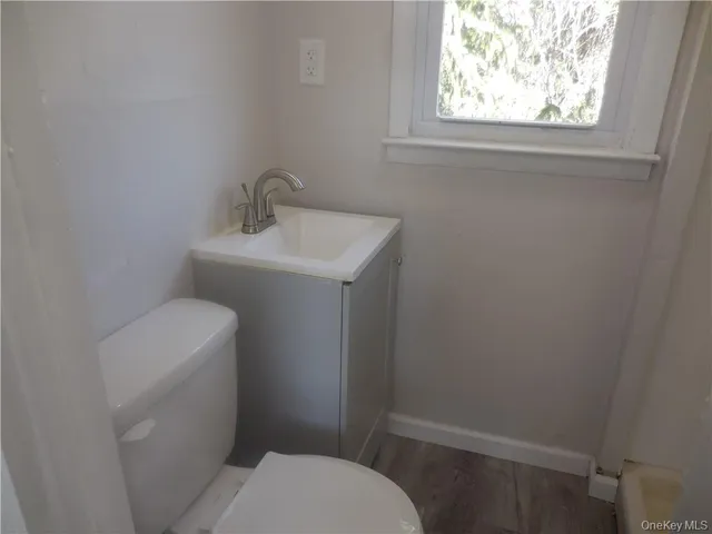 a bathroom with a sink toilet and window