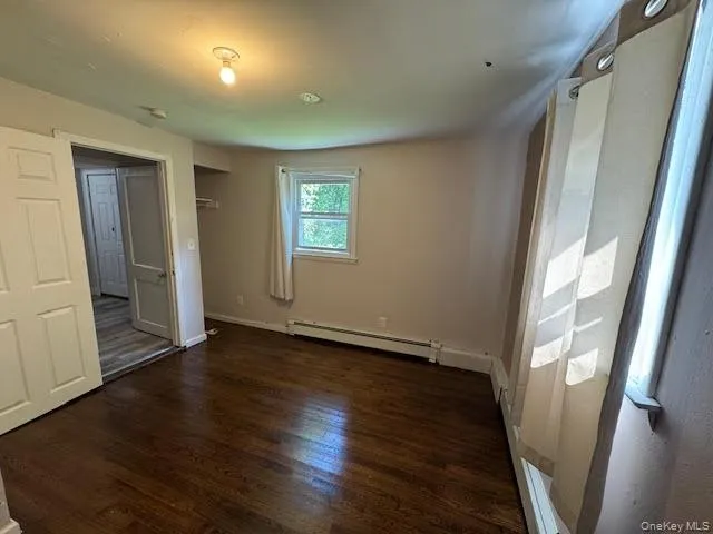 an empty room with wooden floor and entrance
