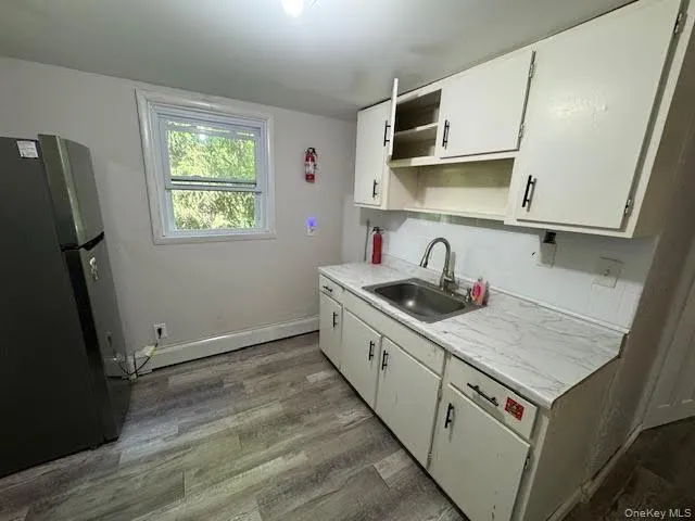 a kitchen with granite countertop a sink a stove and cabinets