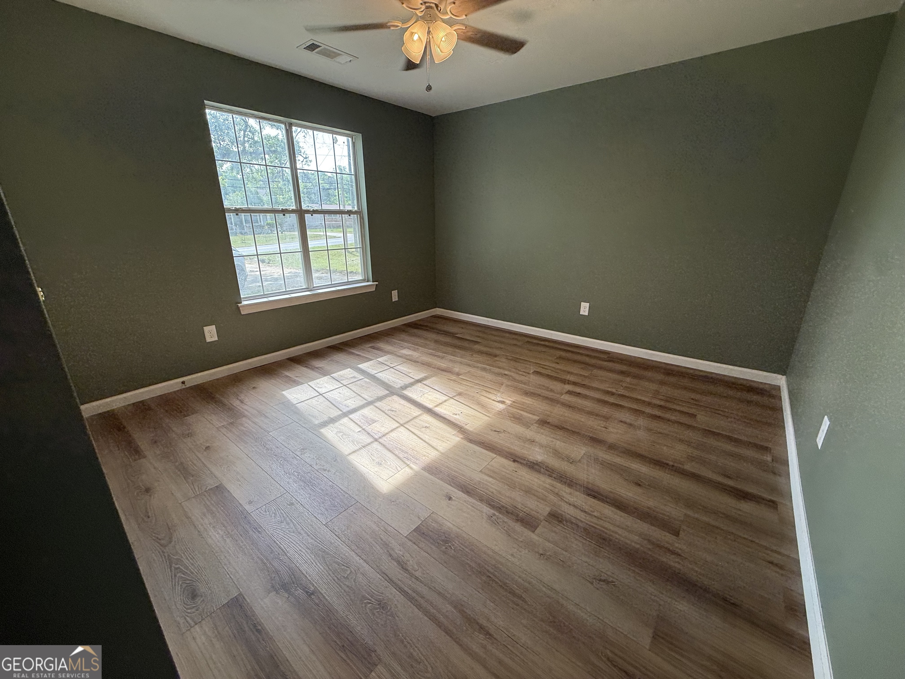 240 Sims Street Barnesville, GA 30204 - Photo 14 of 25 an empty room with windows and chandelier fan