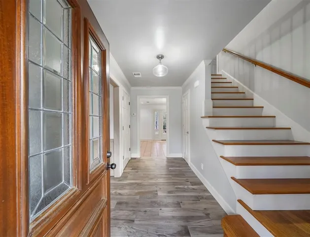 a view of a hallway with wooden floor and staircase