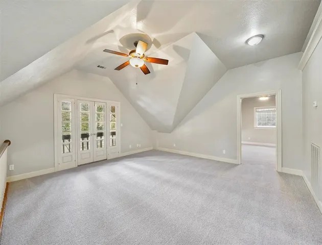 an empty room with windows and ceiling fan