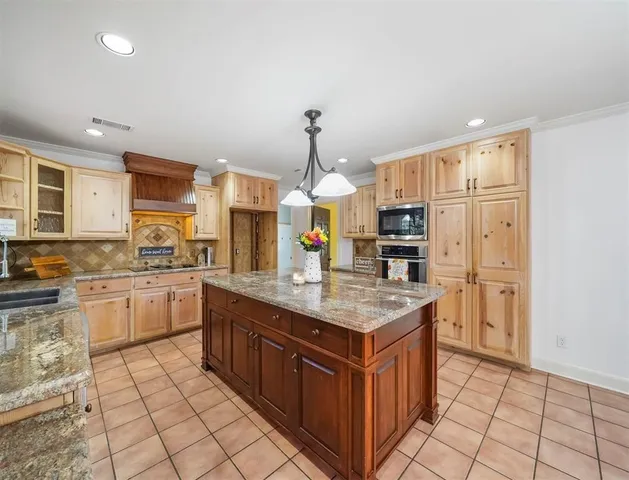 a kitchen with stainless steel appliances granite countertop a stove a sink dishwasher and a refrigerator