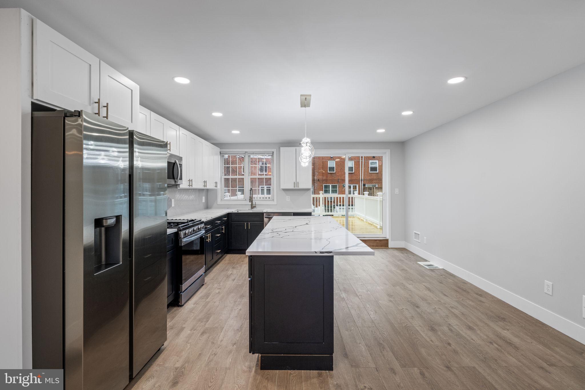 8546 Forrest Avenue Philadelphia, PA 19150 - Photo 11 of 56 a kitchen with stainless steel appliances granite countertop a refrigerator a sink a stove and a wooden floors