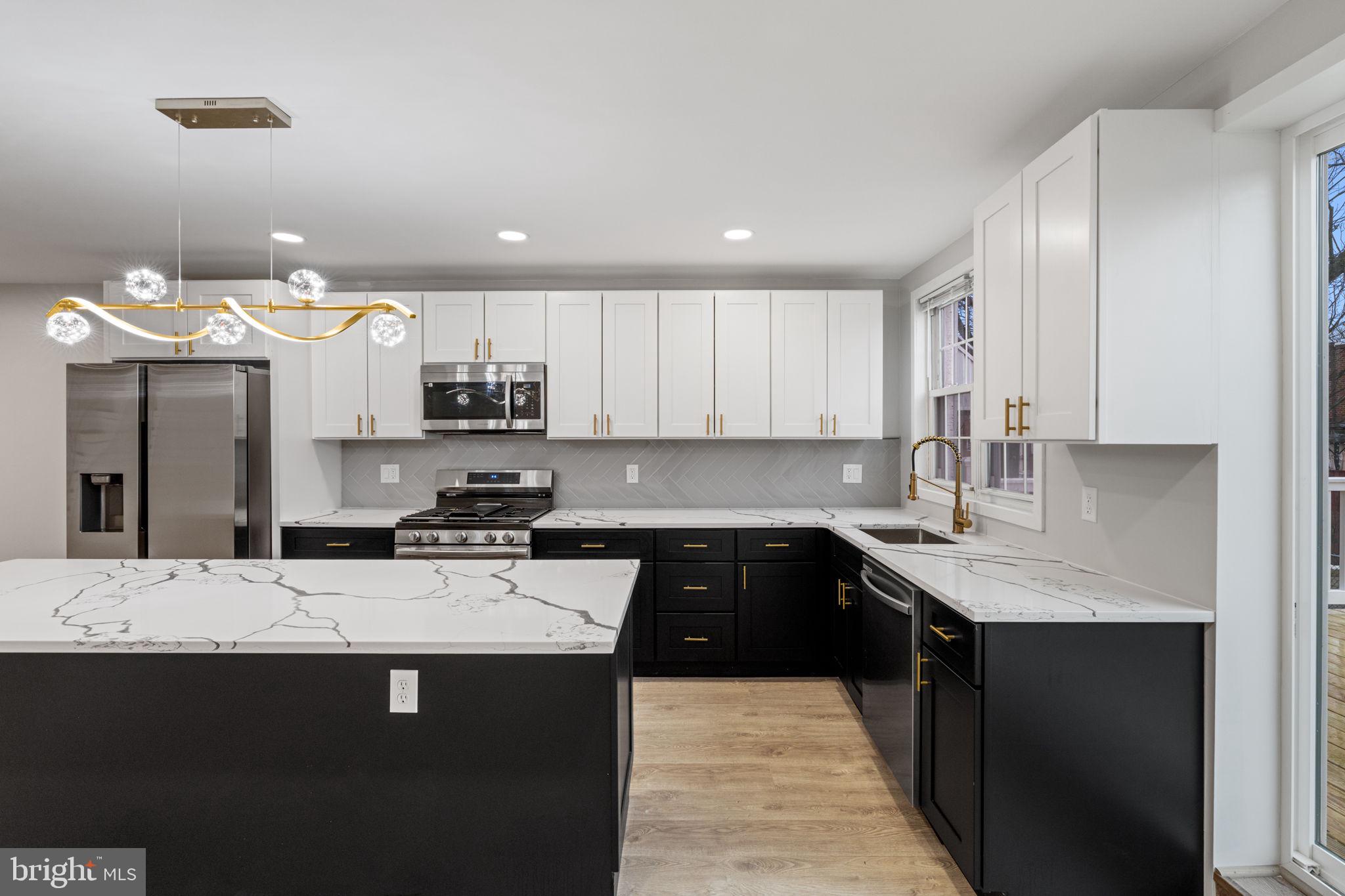 8546 Forrest Avenue Philadelphia, PA 19150 - Photo 13 of 56 a kitchen with stainless steel appliances granite countertop a sink a stove and a refrigerator