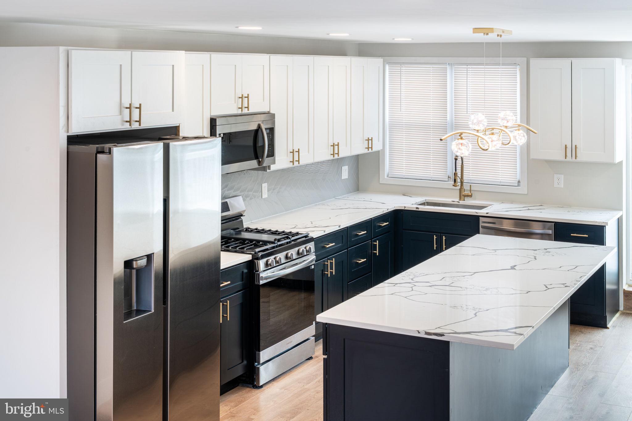 8546 Forrest Avenue Philadelphia, PA 19150 - Photo 15 of 56 a kitchen with stainless steel appliances cabinets and wooden floor