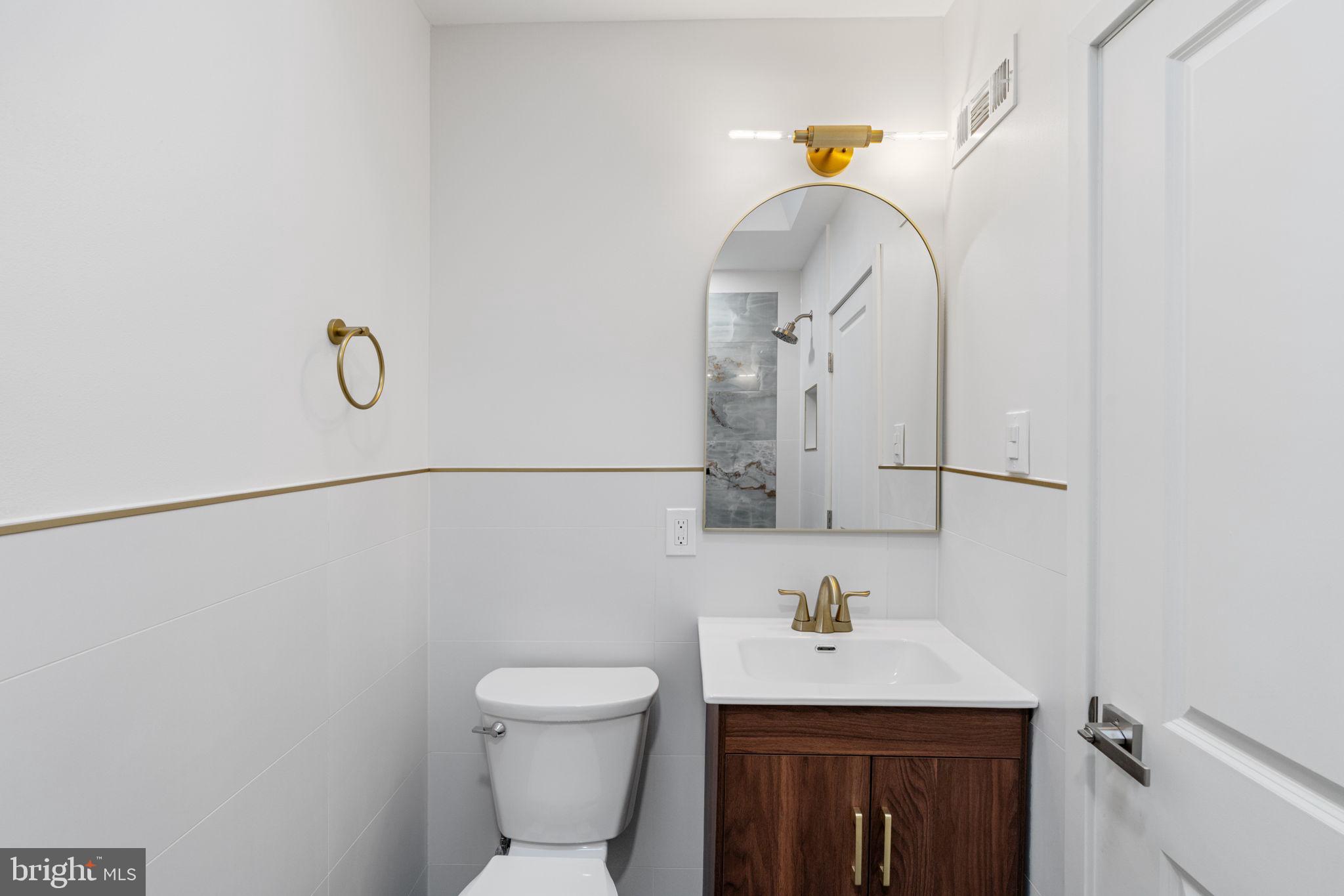 8546 Forrest Avenue Philadelphia, PA 19150 - Photo 27 of 56 a bathroom with a sink a toilet and mirror