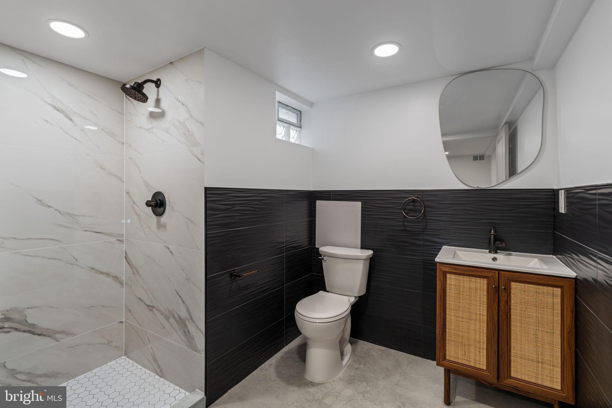 8546 Forrest Avenue Philadelphia, PA 19150 - Photo 45 of 56 a bathroom with a toilet sink and mirror