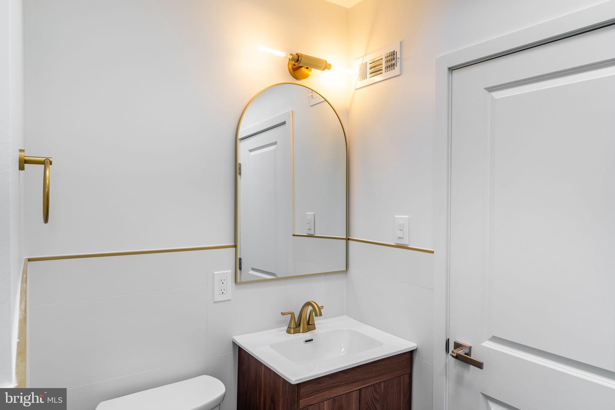 8546 Forrest Avenue Philadelphia, PA 19150 - Photo 51 of 56 a bathroom with a sink a toilet and a mirror