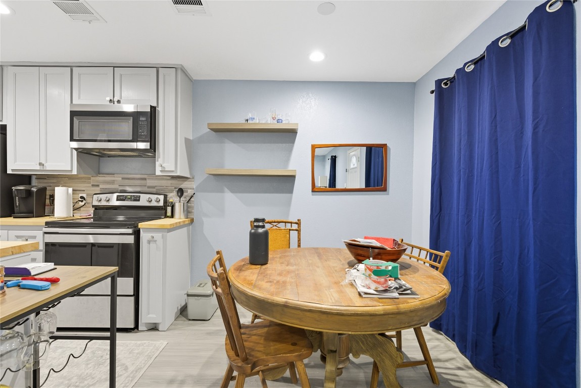 5401 Agua Caliente Cove, Unit B Austin, TX 78744 - Photo 12 of 26 a kitchen with stainless steel appliances kitchen island granite countertop a sink a stove a dining table and chairs
