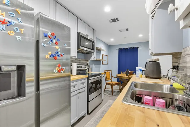 a kitchen with granite countertop a white stove top oven and cabinets
