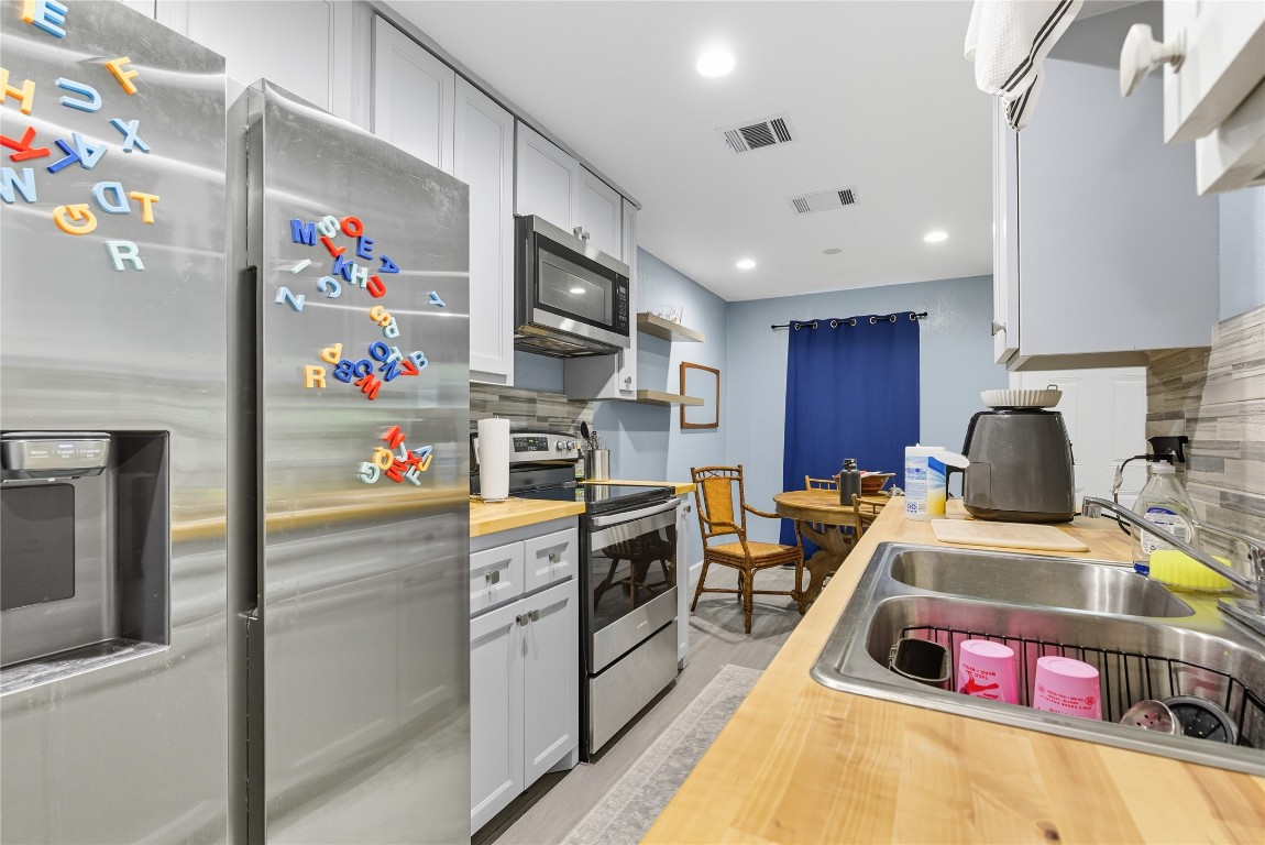 5401 Agua Caliente Cove, Unit B Austin, TX 78744 - Photo 13 of 26 a kitchen with granite countertop a white stove top oven and cabinets
