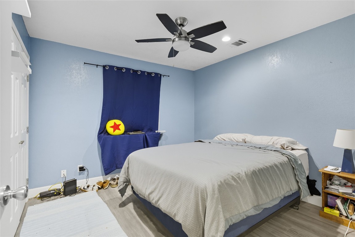 5401 Agua Caliente Cove, Unit B Austin, TX 78744 - Photo 16 of 26 a bedroom with a bed and ceiling fan