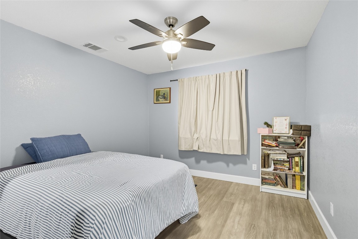 5401 Agua Caliente Cove, Unit B Austin, TX 78744 - Photo 19 of 26 a bedroom with a bed and a chandelier