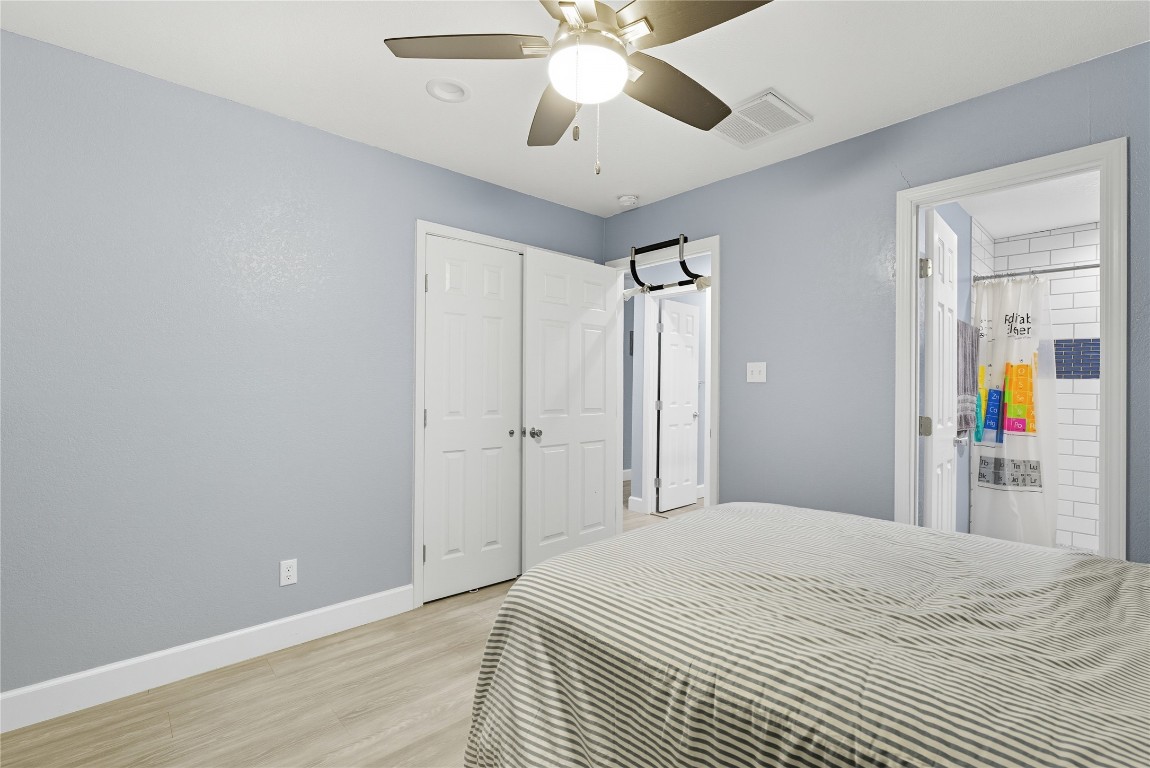 5401 Agua Caliente Cove, Unit B Austin, TX 78744 - Photo 20 of 26 a bedroom with a bed and a chandelier