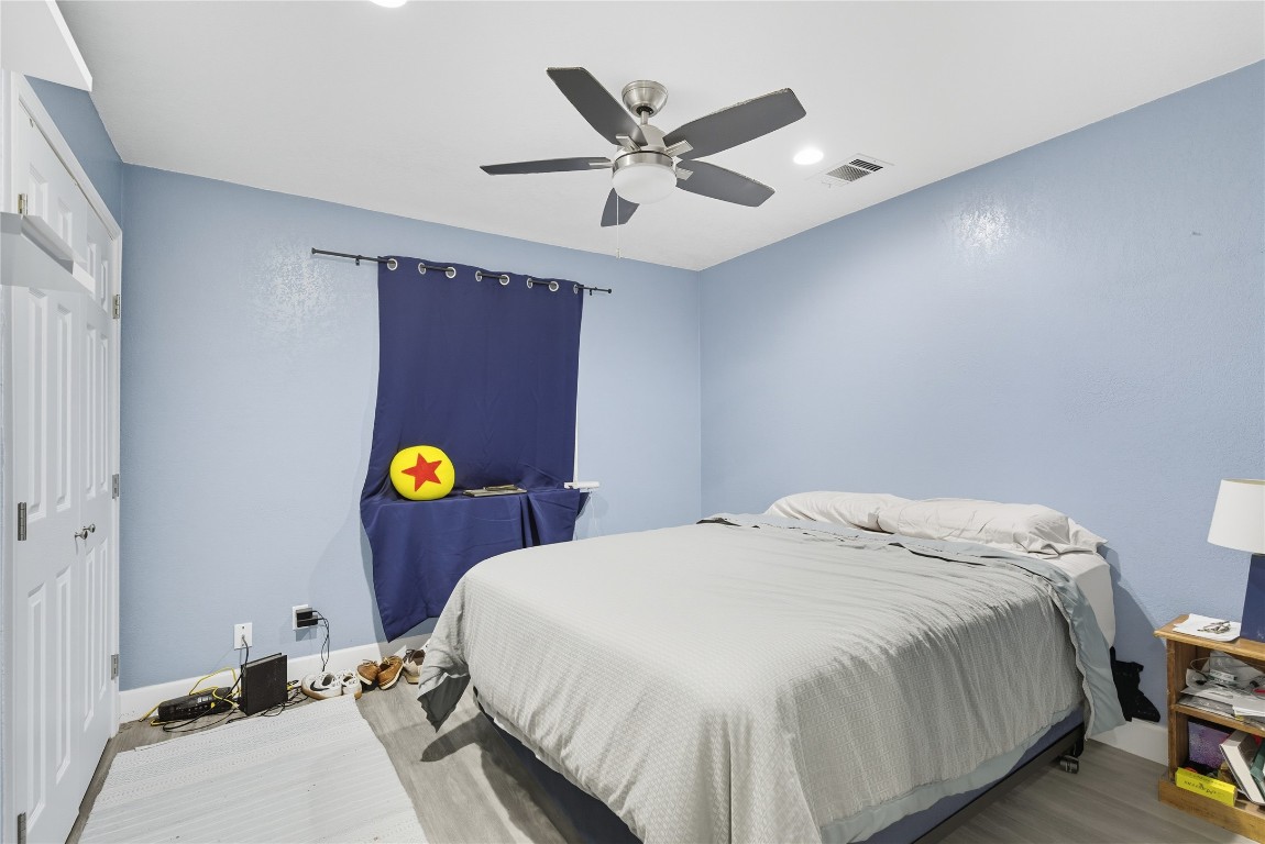 5401 Agua Caliente Cove, Unit B Austin, TX 78744 - Photo 21 of 26 a bed room with a bed and ceiling fan