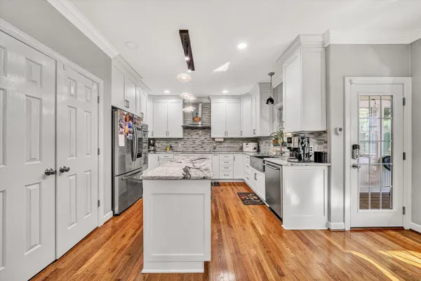 a kitchen with stainless steel appliances granite countertop a stove a sink and a microwave