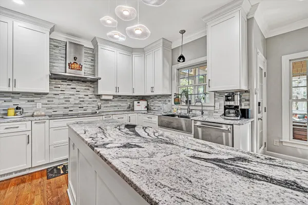 a kitchen with stainless steel appliances granite countertop a sink stove and cabinets
