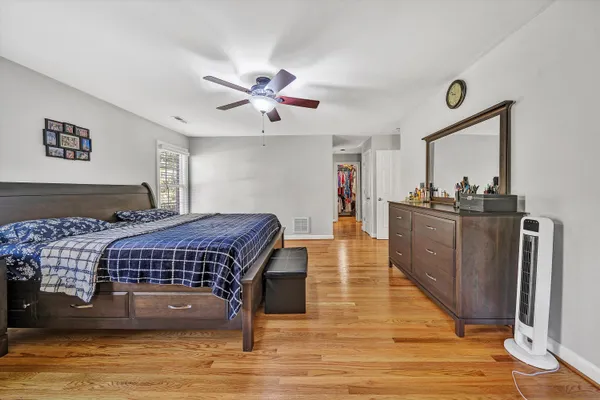 a bedroom with a bed and a dresser next to a window