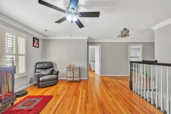 a view of a dining room and livingroom with furniture wooden floor a rug and a chandelier