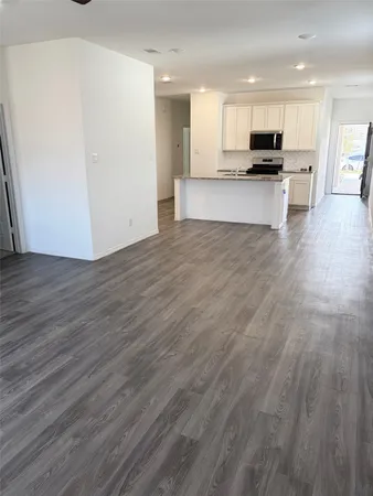 a view of kitchen with wooden floor and electronic appliances