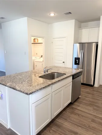 a kitchen with granite countertop a sink stove and refrigerator