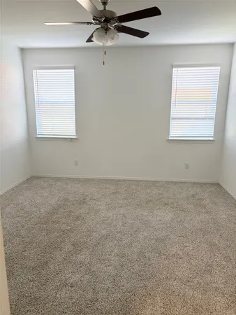 an empty room with a window and a ceiling fan
