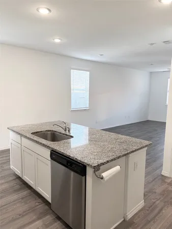 a kitchen with granite countertop a sink and a stove