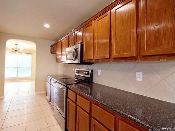 a kitchen with stainless steel appliances granite countertop a sink a stove and cabinets