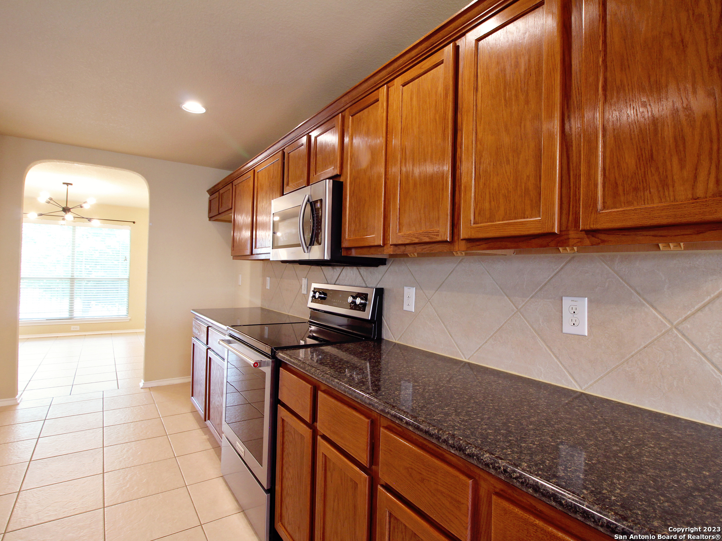 9627 Mediator Run Converse, TX 78109 - Photo 15 of 41 a kitchen with stainless steel appliances granite countertop a sink a stove and cabinets