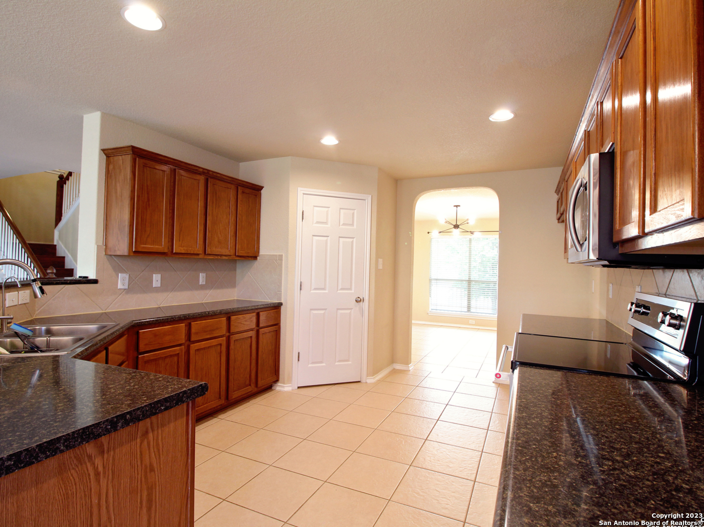 9627 Mediator Run Converse, TX 78109 - Photo 16 of 41 a kitchen with stainless steel appliances granite countertop a sink stove and cabinets