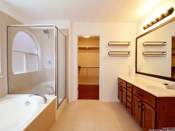a bathroom with a tub sink and mirror