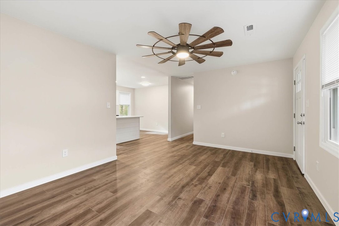 7603 Golf Course Drive Disputanta, VA 23842 - Photo 16 of 24 a view of an empty room with wooden floor and a ceiling fan