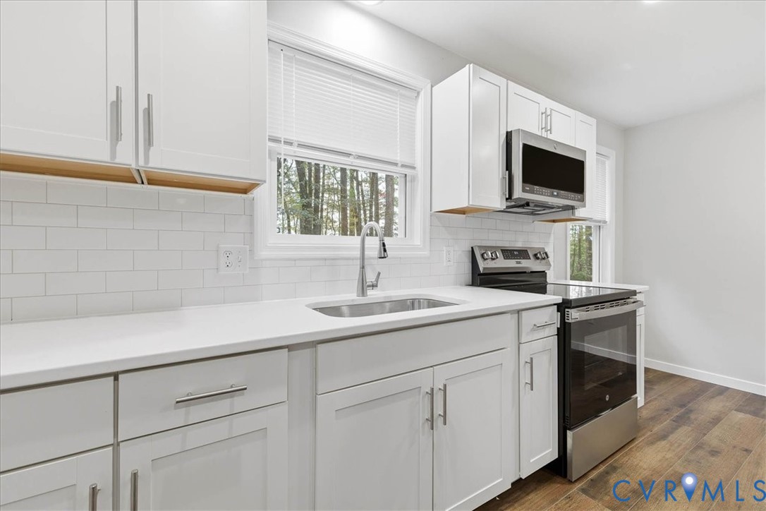 7603 Golf Course Drive Disputanta, VA 23842 - Photo 18 of 24 a kitchen with stainless steel appliances granite countertop a sink and a microwave