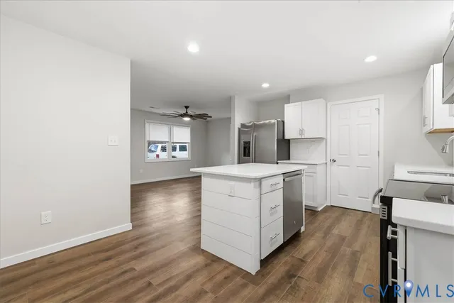 a kitchen with white cabinets and appliances