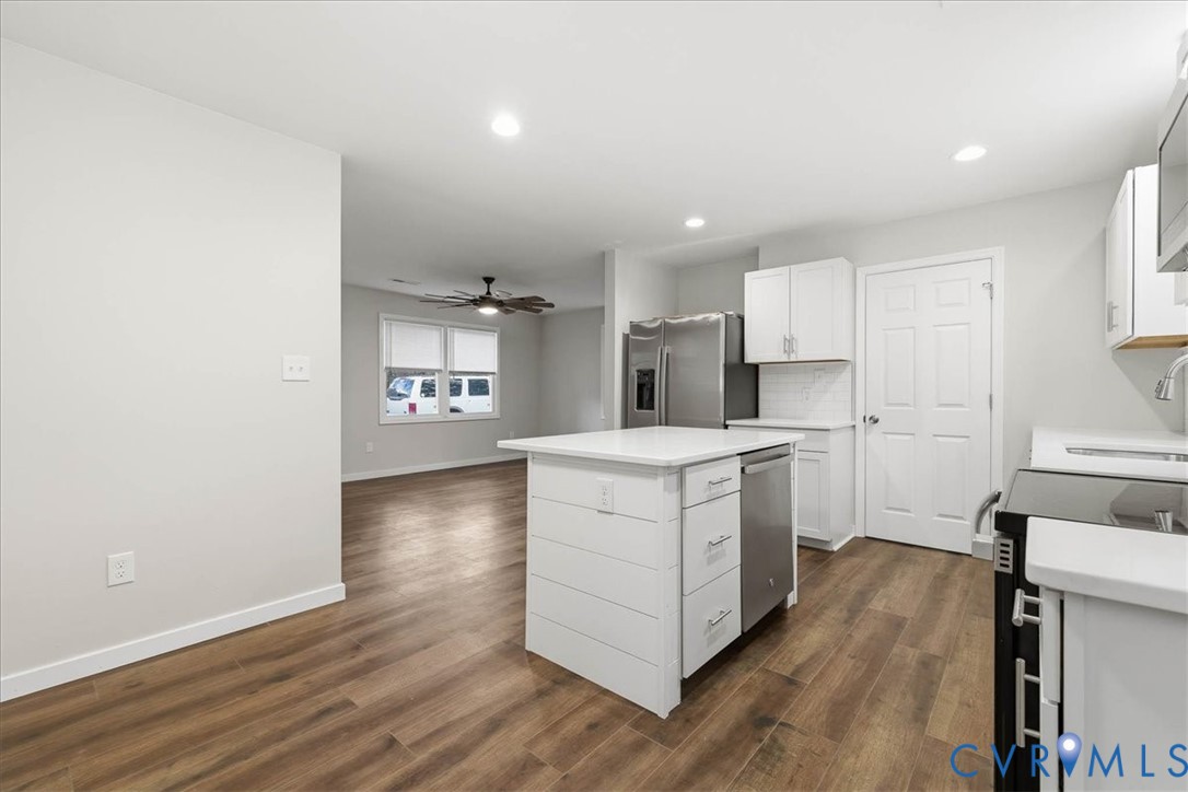 7603 Golf Course Drive Disputanta, VA 23842 - Photo 19 of 24 a kitchen with a white cabinets and wooden floor