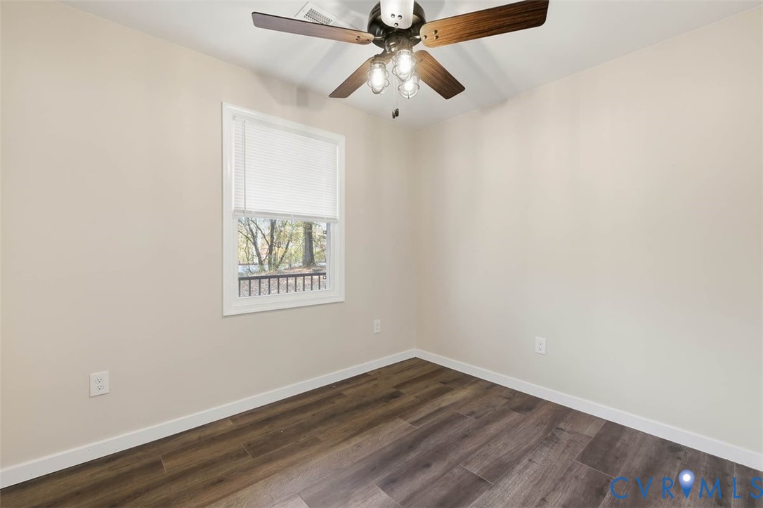 7603 Golf Course Drive Disputanta, VA 23842 - Photo 23 of 24 an empty room with wooden floor ceiling fan and windows