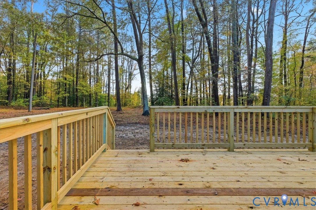 7603 Golf Course Drive Disputanta, VA 23842 - Photo 24 of 24 a view of a deck with large trees and wooden fence
