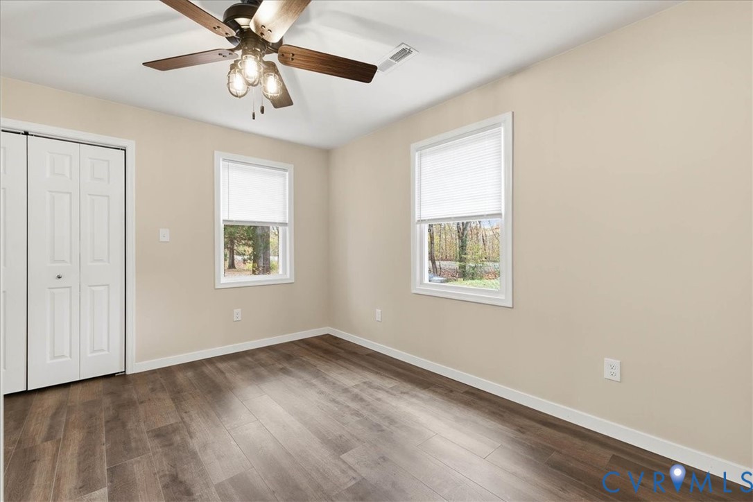 7603 Golf Course Drive Disputanta, VA 23842 - Photo 9 of 24 a view of an empty room with a window and a ceiling fan